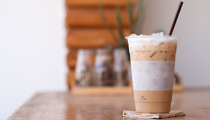 Close up of Iced coffee with straw kept on a wooden table