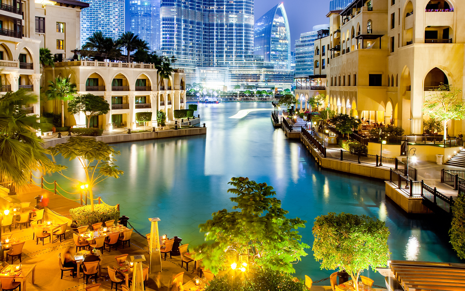 Souk al Bahar at night with illuminated buildings and waterfront dining in Dubai.