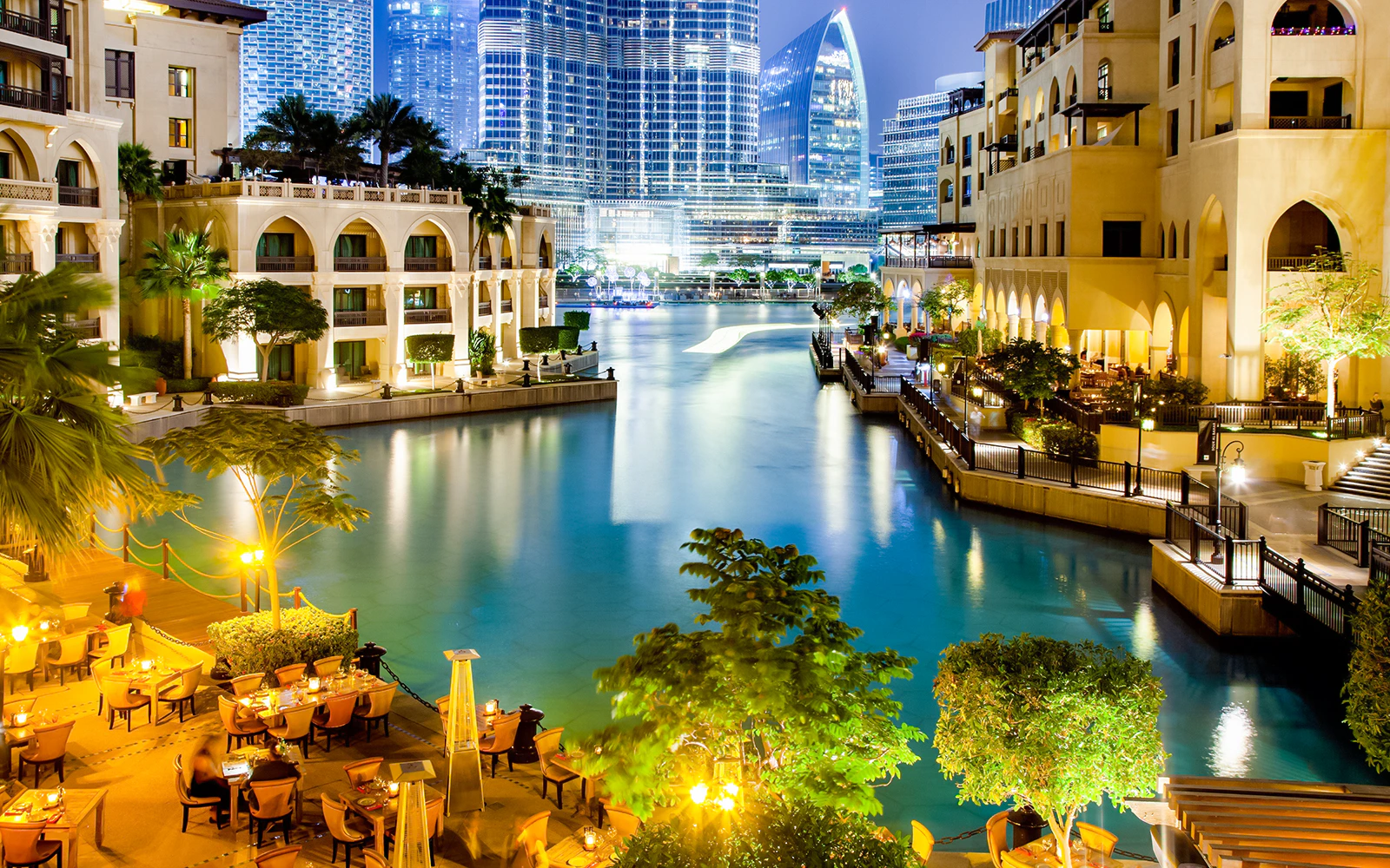 Souk al Bahar at night with illuminated buildings and waterfront dining in Dubai.