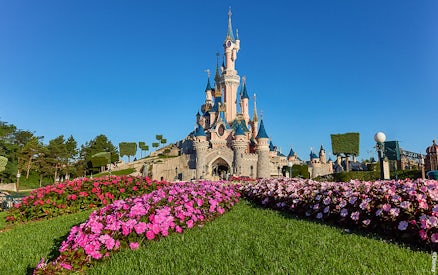 Disneyland Paris castle with vibrant flower garden, part of the Royal Combo tour.
