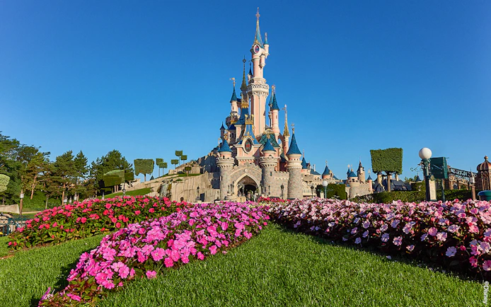 Disneyland Paris castle with vibrant flower garden, part of the Royal Combo tour.