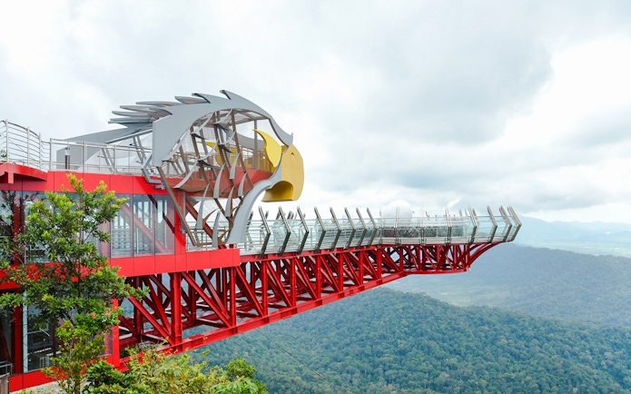 Langkawi Skywalk with eagle-themed structure overlooking lush green forest.