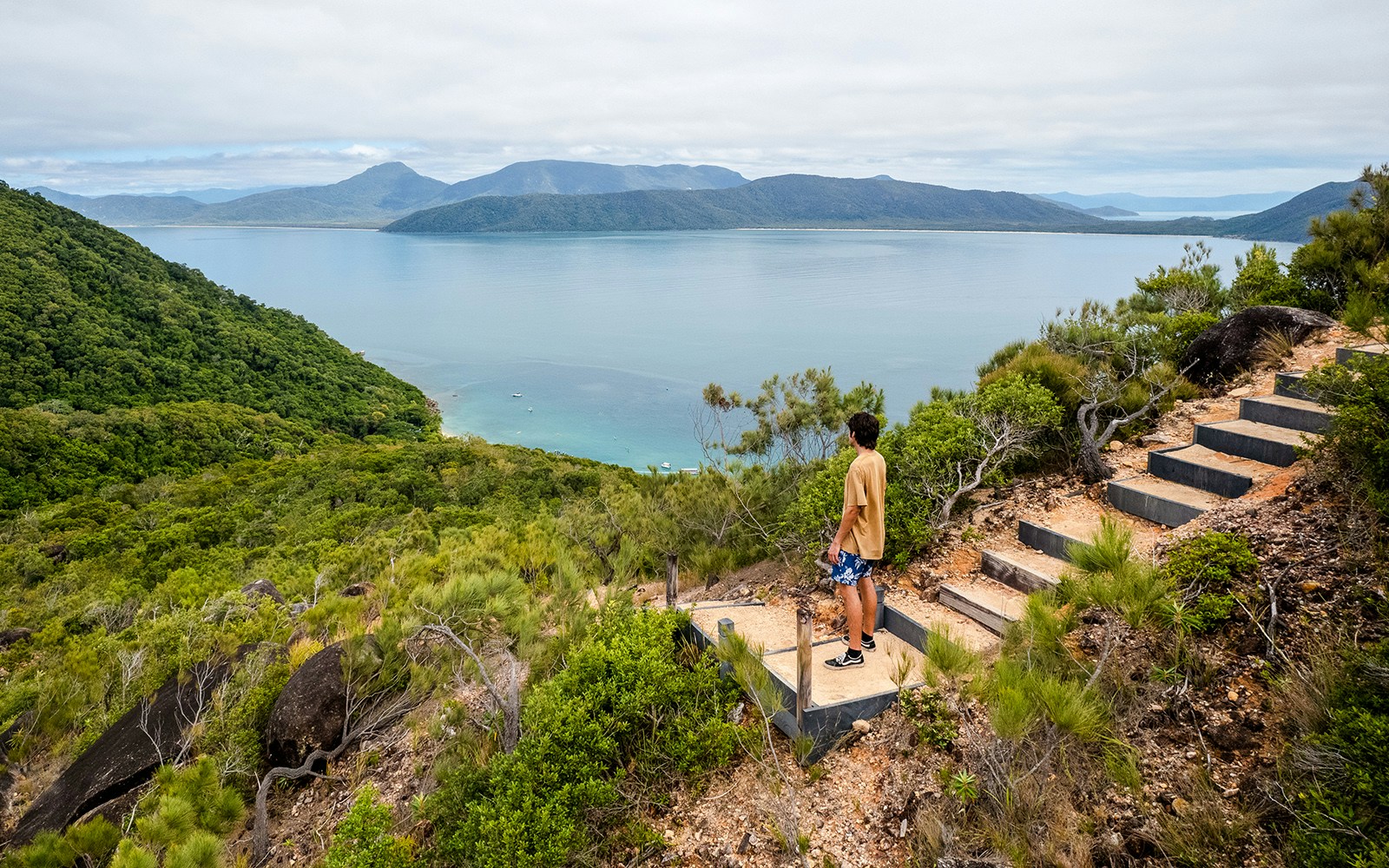 Person overlooking ocean and lush hills on Fitzroy Island adventure trail.