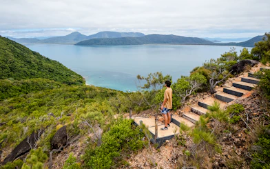 Person overlooking ocean and lush hills on Fitzroy Island adventure trail.