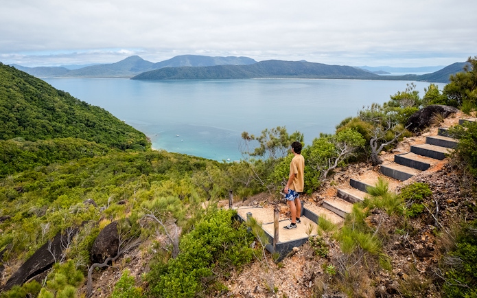 Person overlooking ocean and lush hills on Fitzroy Island adventure trail.