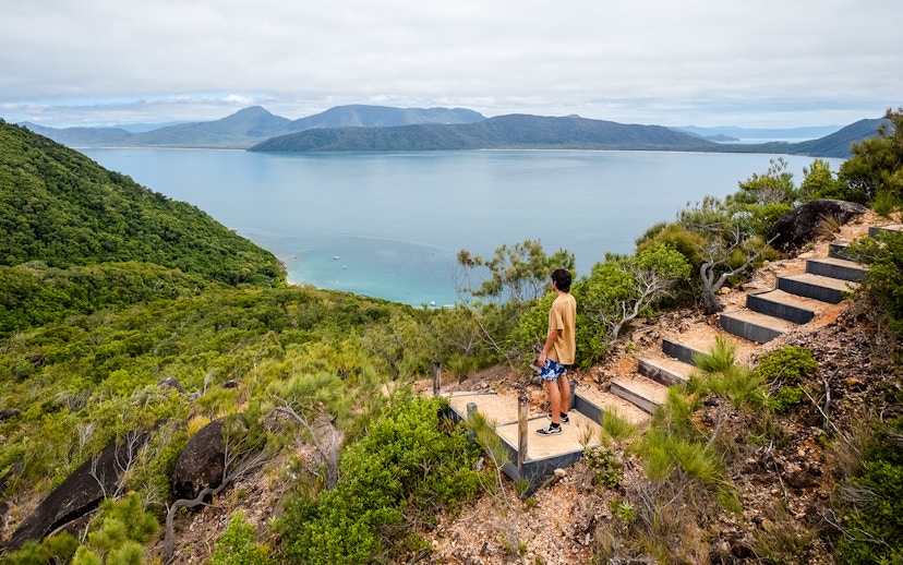 Person overlooking ocean and lush hills on Fitzroy Island adventure trail.