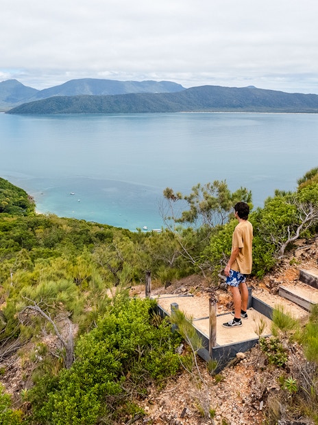 Person overlooking ocean and lush hills on Fitzroy Island adventure trail.