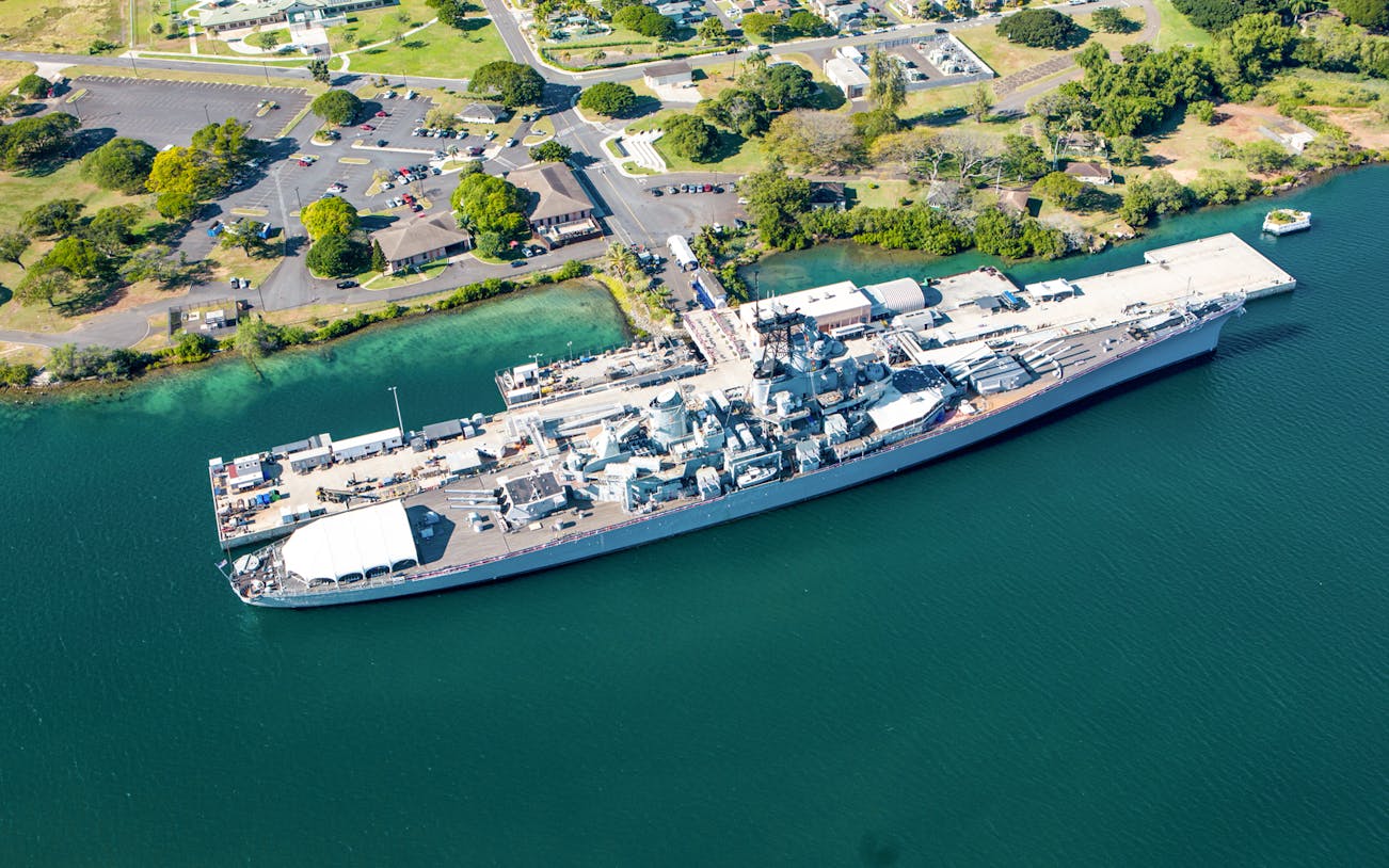 Battleship Missouri docked at Pearl Harbor, Oahu, with visitors exploring the historic naval vessel.