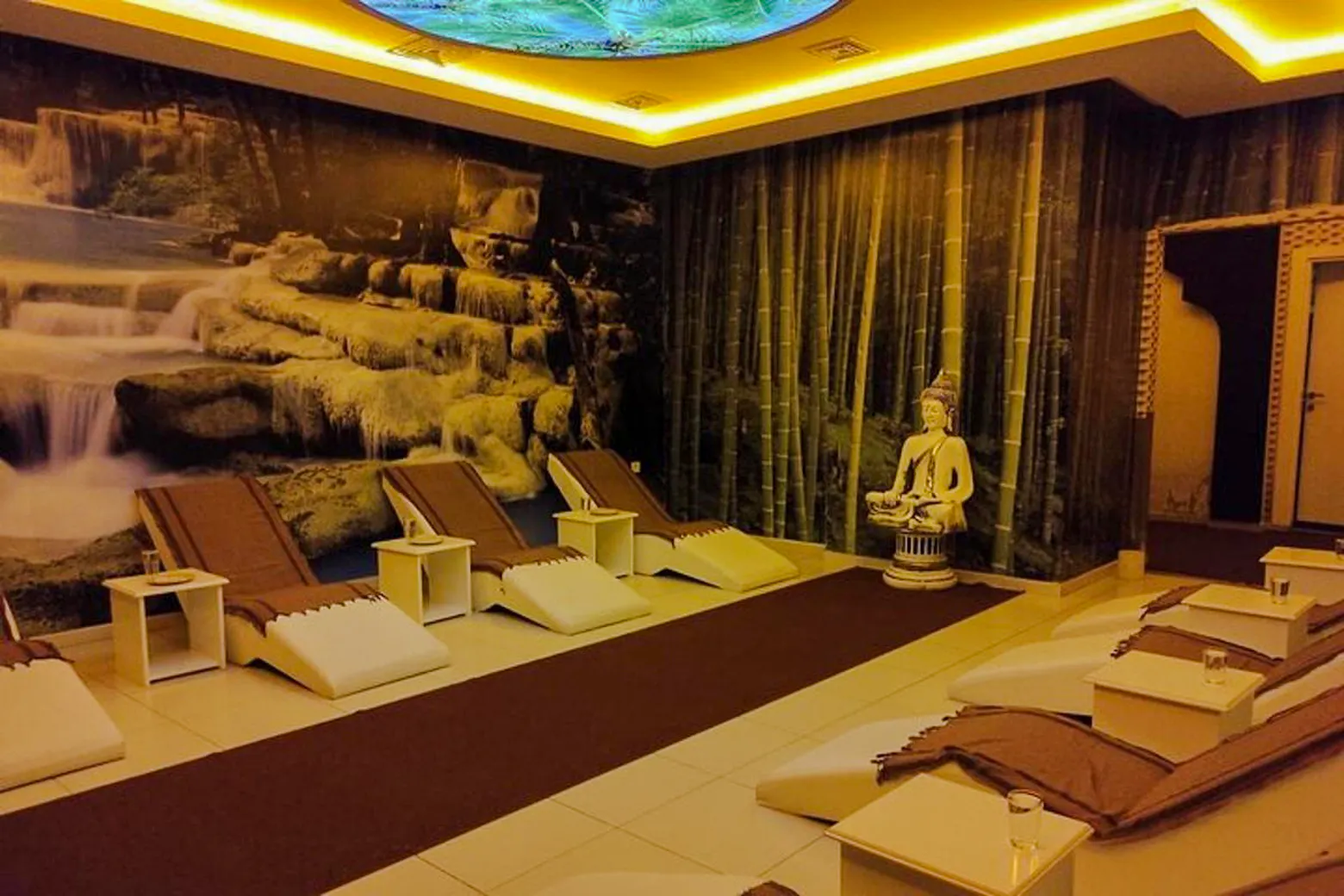 Spa relaxation area with lounge chairs and a Buddha statue, Alanya Turkish Bath.