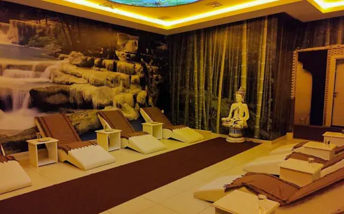 Spa relaxation area with lounge chairs and a Buddha statue, Alanya Turkish Bath.