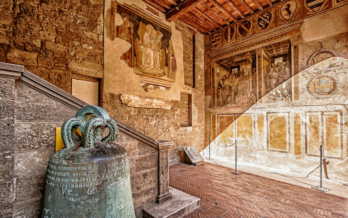 Siena Cathedral interior with historic frescoes and ancient bell, Italy.