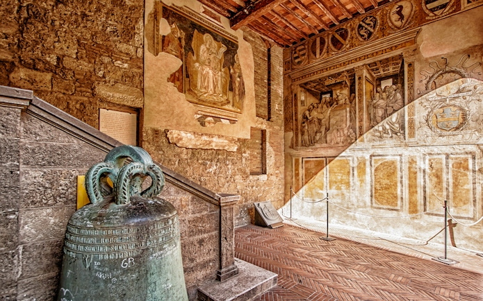 Siena Cathedral interior with historic frescoes and ancient bell, Italy.
