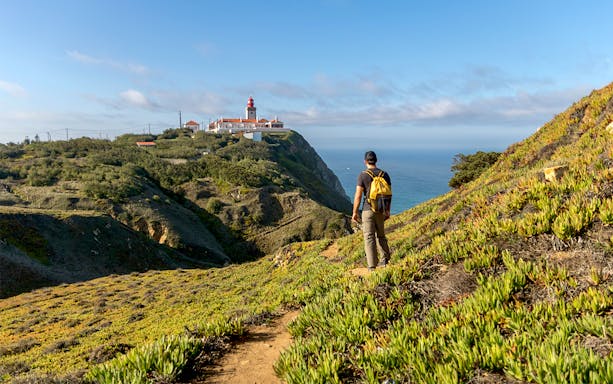 Traveler hiking towards Cabo da Roca lighthouse on a private tour from Lisbon.