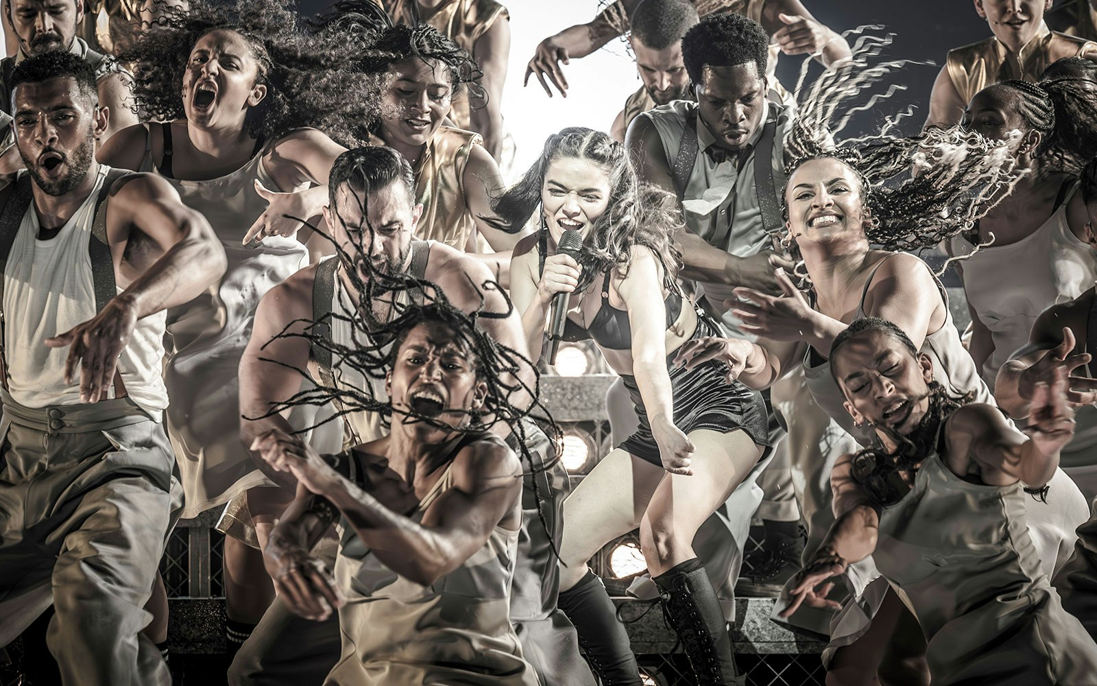 Performers energetically dancing during the Evita Musical show.