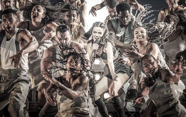 Performers energetically dancing during the Evita Musical show.