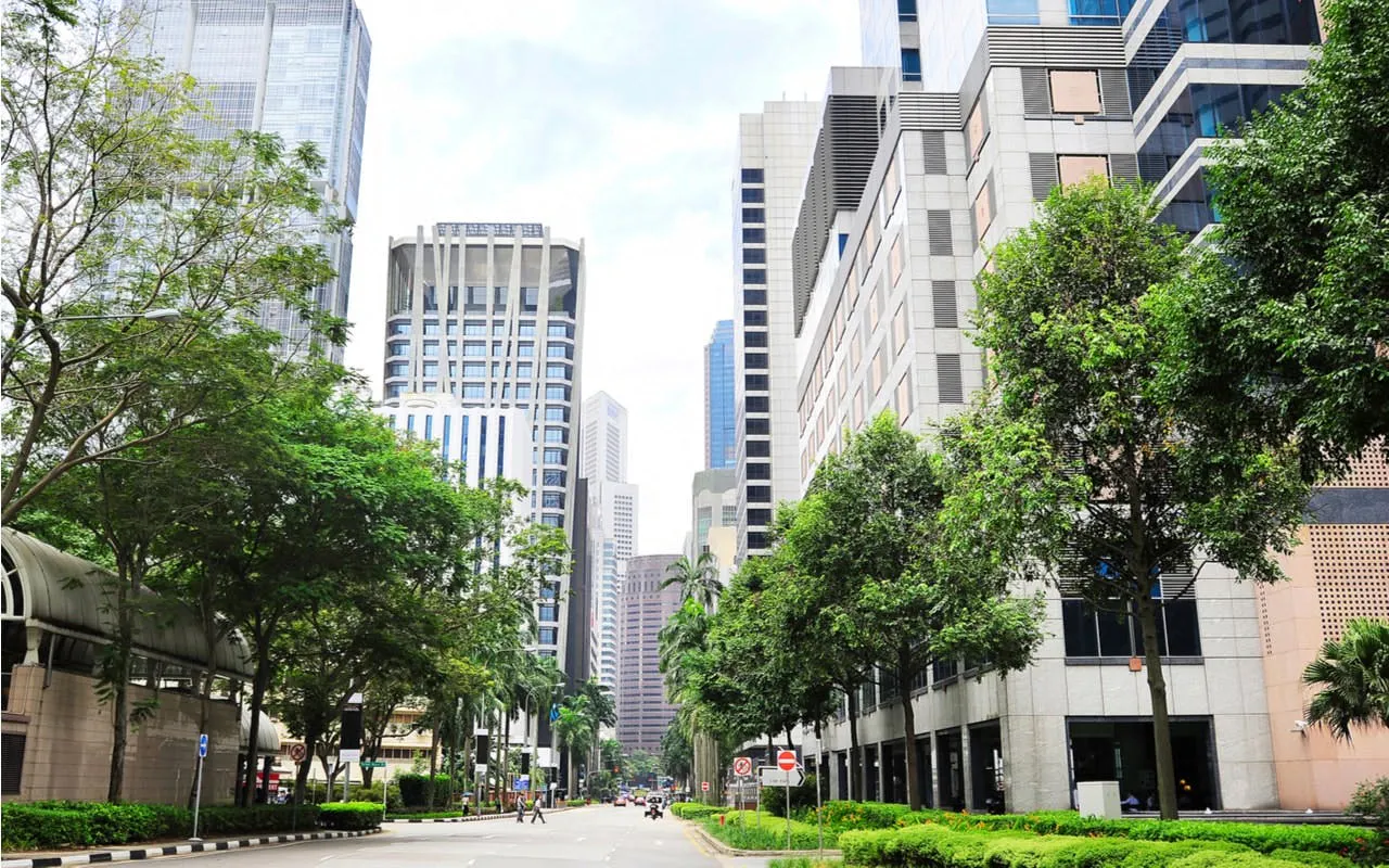 Street view of modern skyscrapers and greenery in Singapore for self-guided city exploration game.
