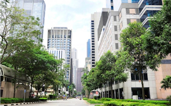 Street view of modern skyscrapers and greenery in Singapore for self-guided city exploration game.