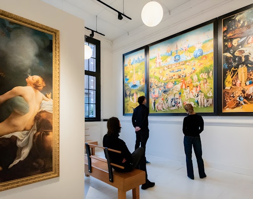Visitors viewing art in an Amsterdam museum gallery.