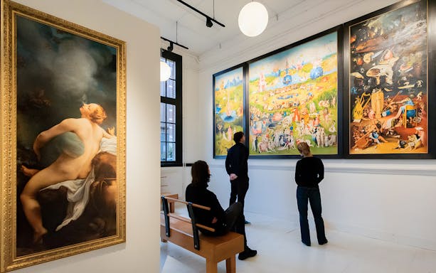 Visitors viewing art in an Amsterdam museum gallery.