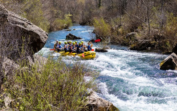 Rafting group navigating rapids on Cetina River, Croatia.