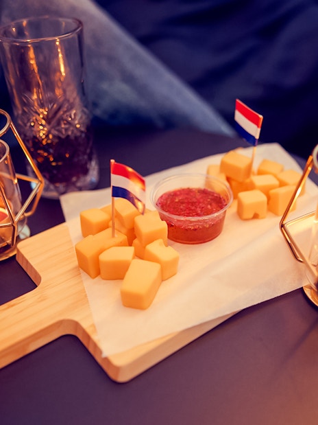 Candlelit table with wine, cheese platter, and small flags on the Evening Candle Light Cruise.