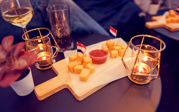 Candlelit table with wine, cheese platter, and small flags on the Evening Candle Light Cruise.