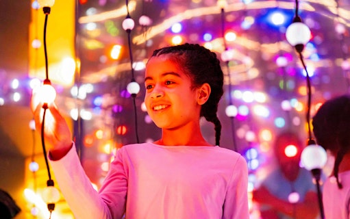 Child interacting with colorful lights at Astronomers Take Over, National Maritime Museum.