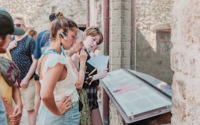Visitors reading information plaques on a Pompeii VIP small group tour.