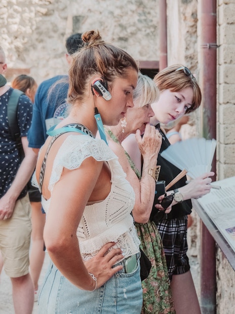 Visitors reading information plaques on a Pompeii VIP small group tour.