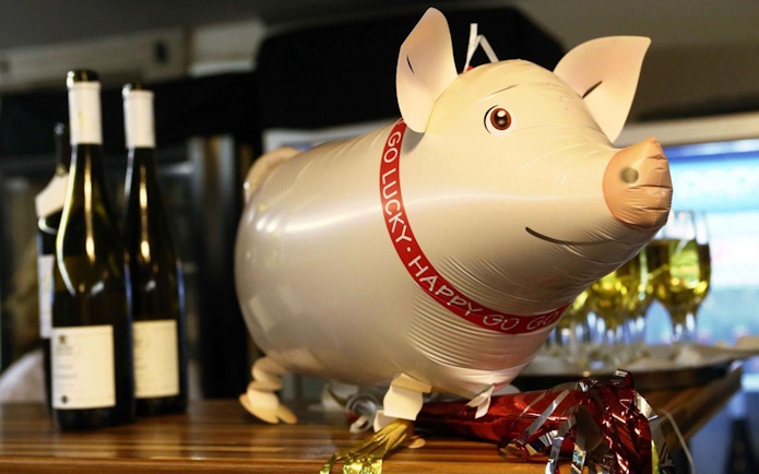 Pig balloon decoration with wine bottles and glasses on New Year’s Eve cruise in Budapest.