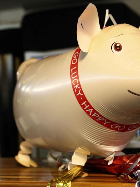 Pig balloon decoration with wine bottles and glasses on New Year’s Eve cruise in Budapest.
