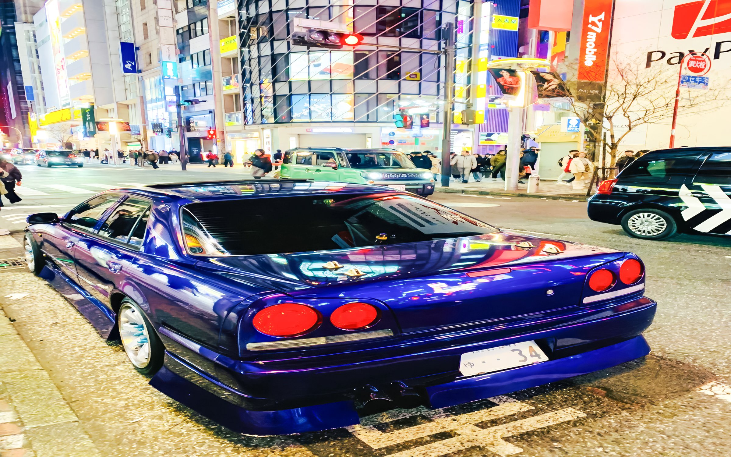 Super car parked on a busy street in Tokyo at night.