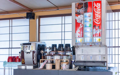 Beverage station with coffee machine and soda dispenser on Yakatabune dinner cruise.