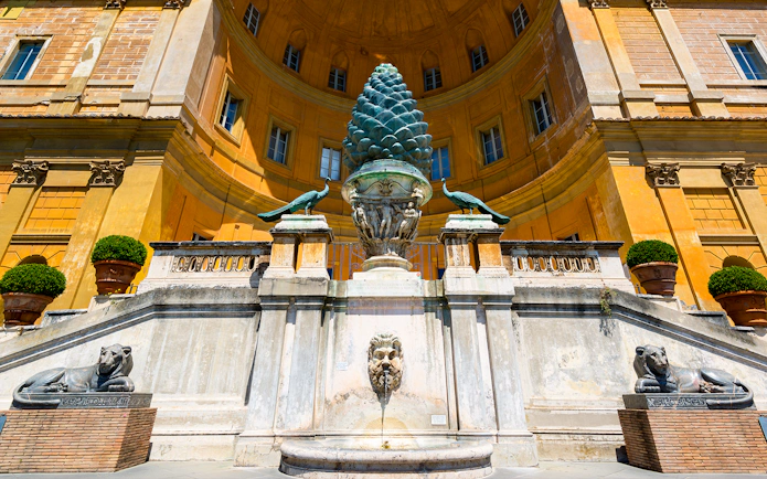 Vatican Museums courtyard with bronze pinecone sculpture and peacocks, Rome, Italy.