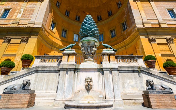 Vatican Museums courtyard with bronze pinecone sculpture and peacocks, Rome, Italy.