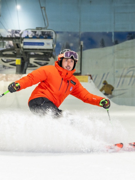 Skier in orange jacket on indoor slope at Ski Dubai.