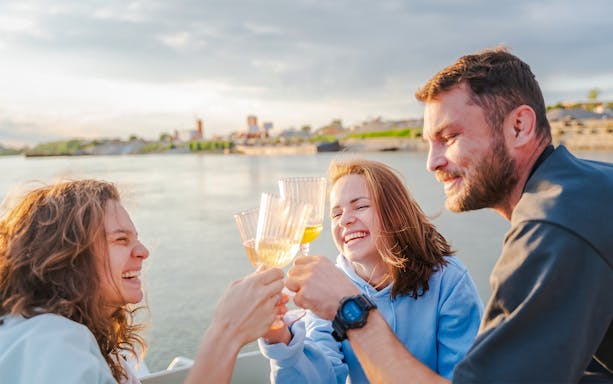 Group of friends toasting on a boat at sunset.