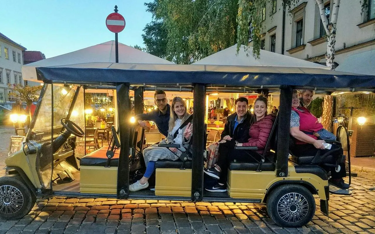 Golf cart with tourists in Krakow Kazimierz Jewish Quarter tour.