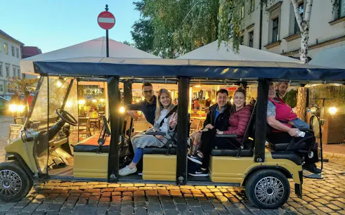 Golf cart with tourists in Krakow Kazimierz Jewish Quarter tour.