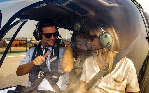 Pilot and passenger in helicopter cockpit during Lisbon coastline flight.