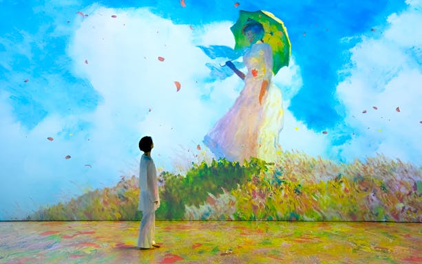 Person viewing Monet's Woman with a Parasol at immersive exhibition in Singapore.