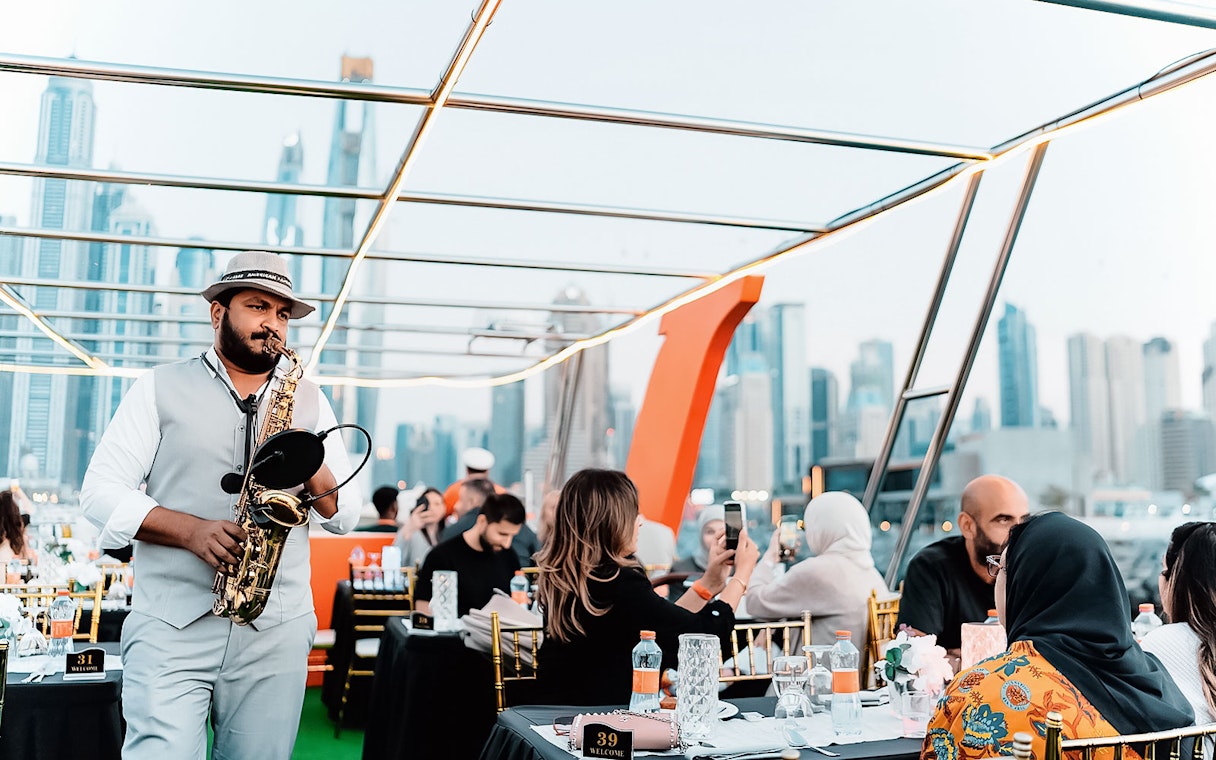 Saxophonist performing on a Dubai Marina sunset cruise with buffet dinner.
