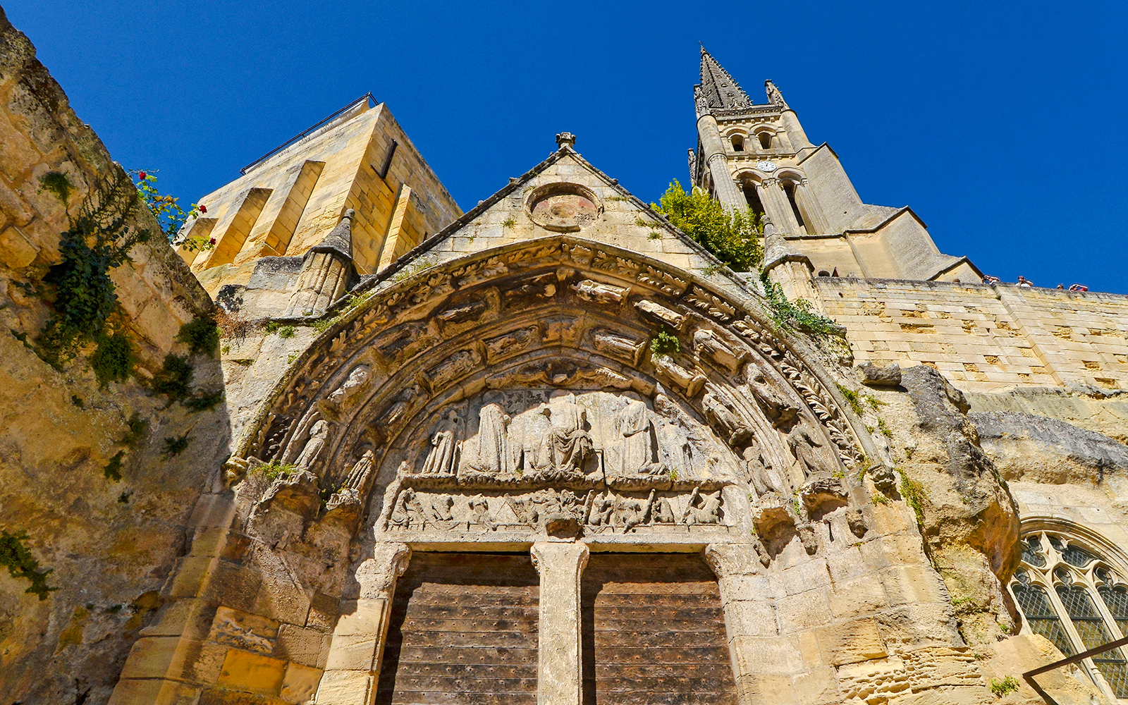 Église Saint-Étienne facade with detailed stone carvings in Saint-Emilion, France.