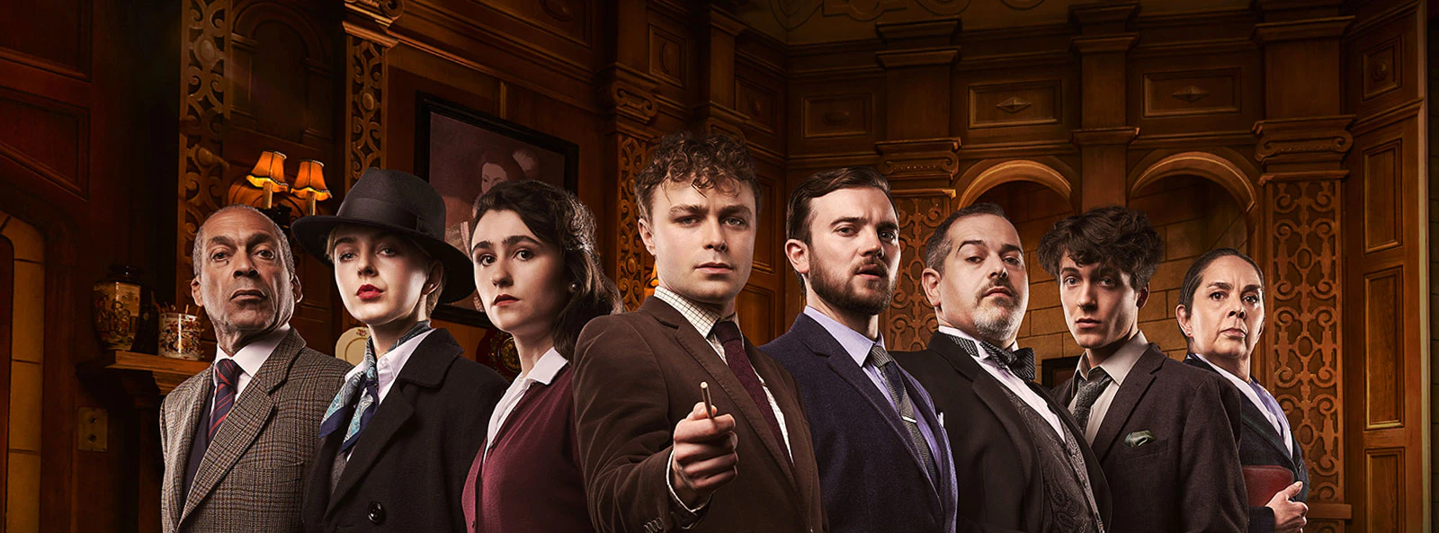 Cast of "The Mousetrap" in period costumes on stage.