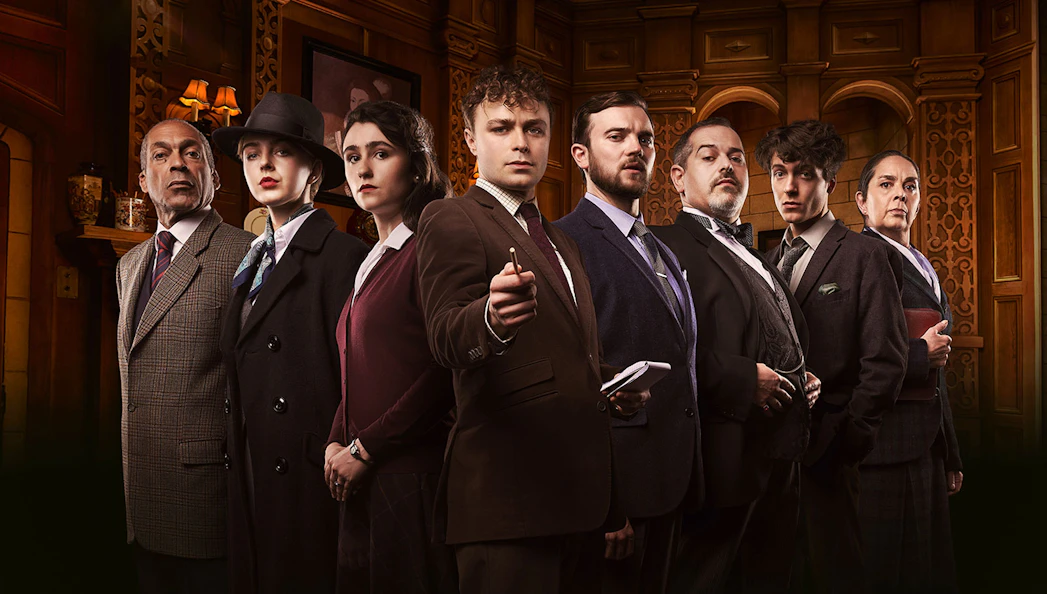 Cast of "The Mousetrap" in period costumes on stage.