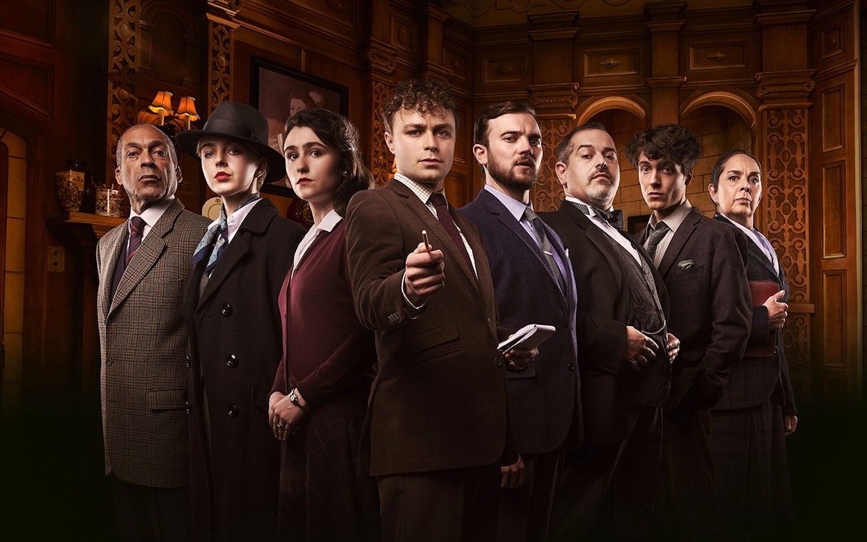 Cast of "The Mousetrap" in period costumes on stage.