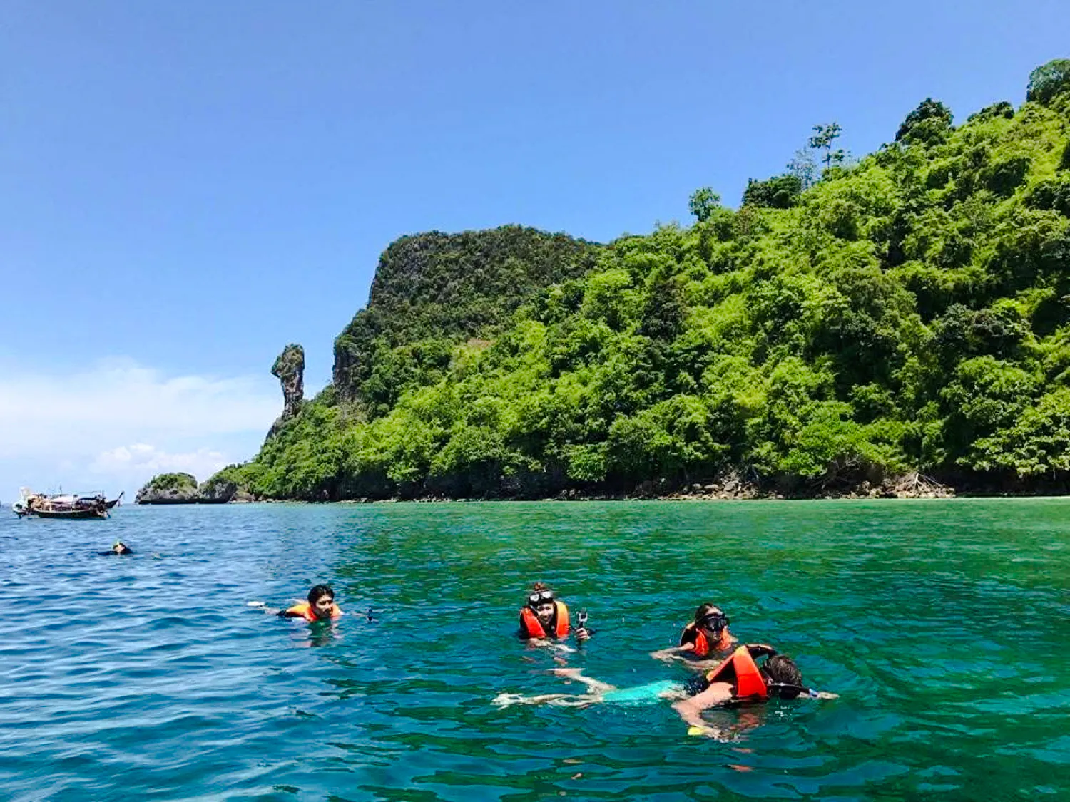 Snorkelers exploring clear waters near lush islands on Krabi's Half Day 3 Islands tour.