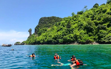 Snorkelers exploring clear waters near lush islands on Krabi's Half Day 3 Islands tour.