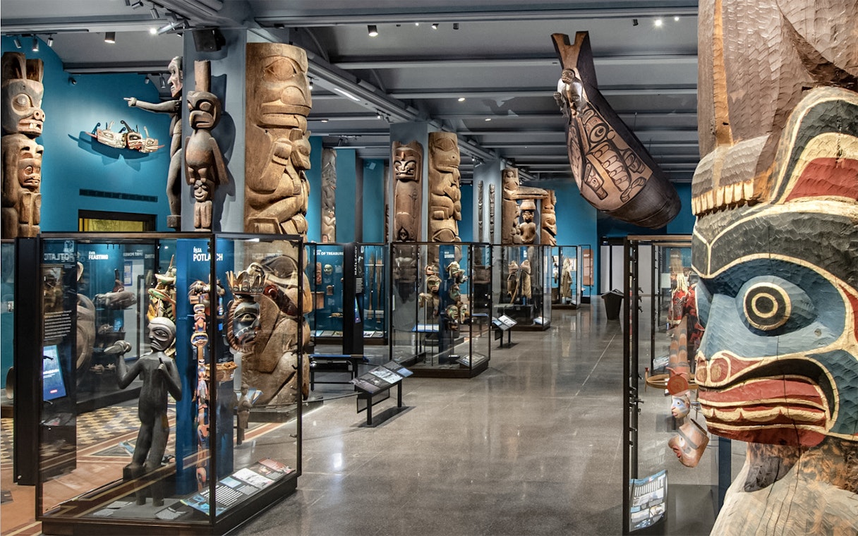 Native American totem poles and artifacts in the American Museum of Natural History exhibit hall.