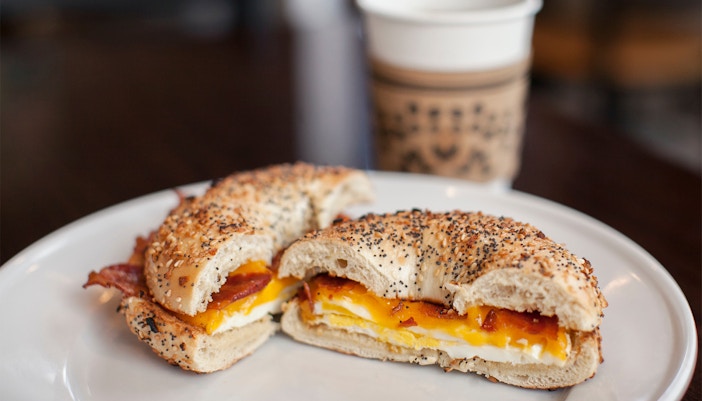 Bagel sandwich with smoked salmon and cream cheese on a wooden table in New York City.